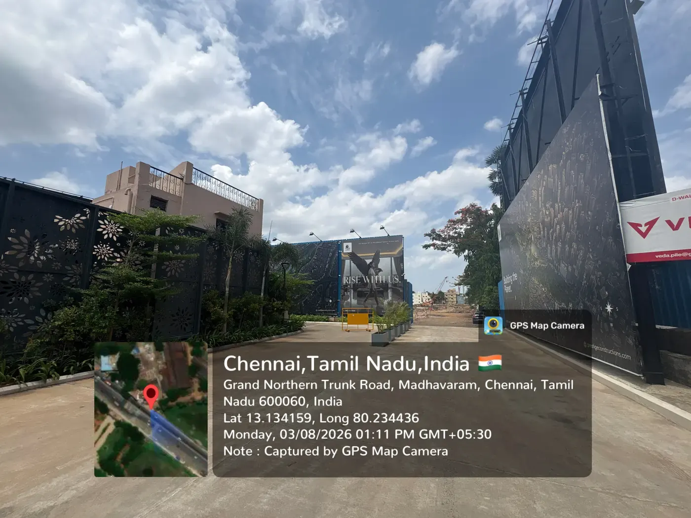 Prestige Palm Court sales gallery driveway with Prestige hoardings and Grand Northern Trunk Road frontage, Madhavaram, August 2026