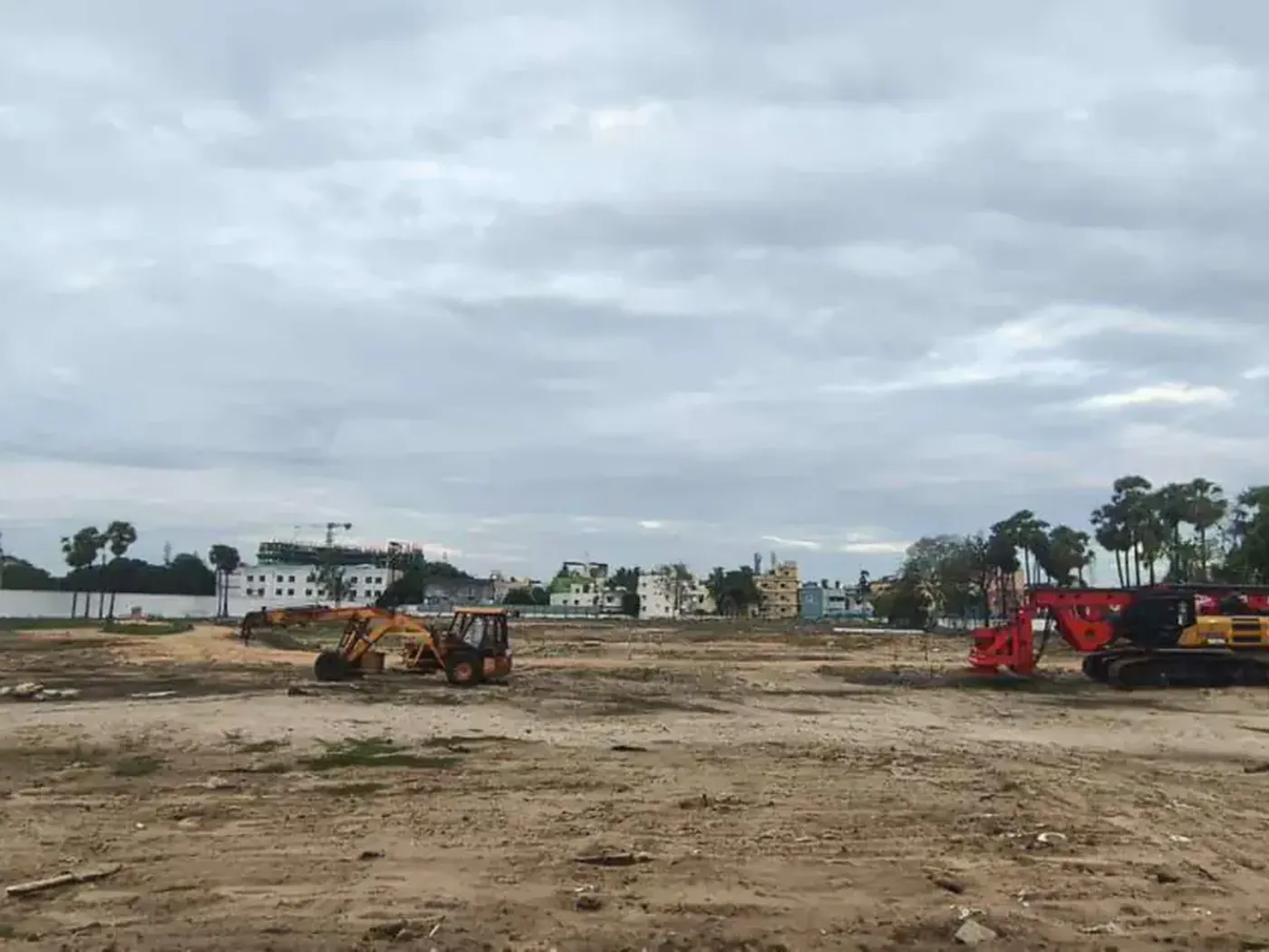 Cleared Prestige Palm Court plot with JCB backhoe and Sany piling rig staged for foundation works, Madhavaram, August 2026